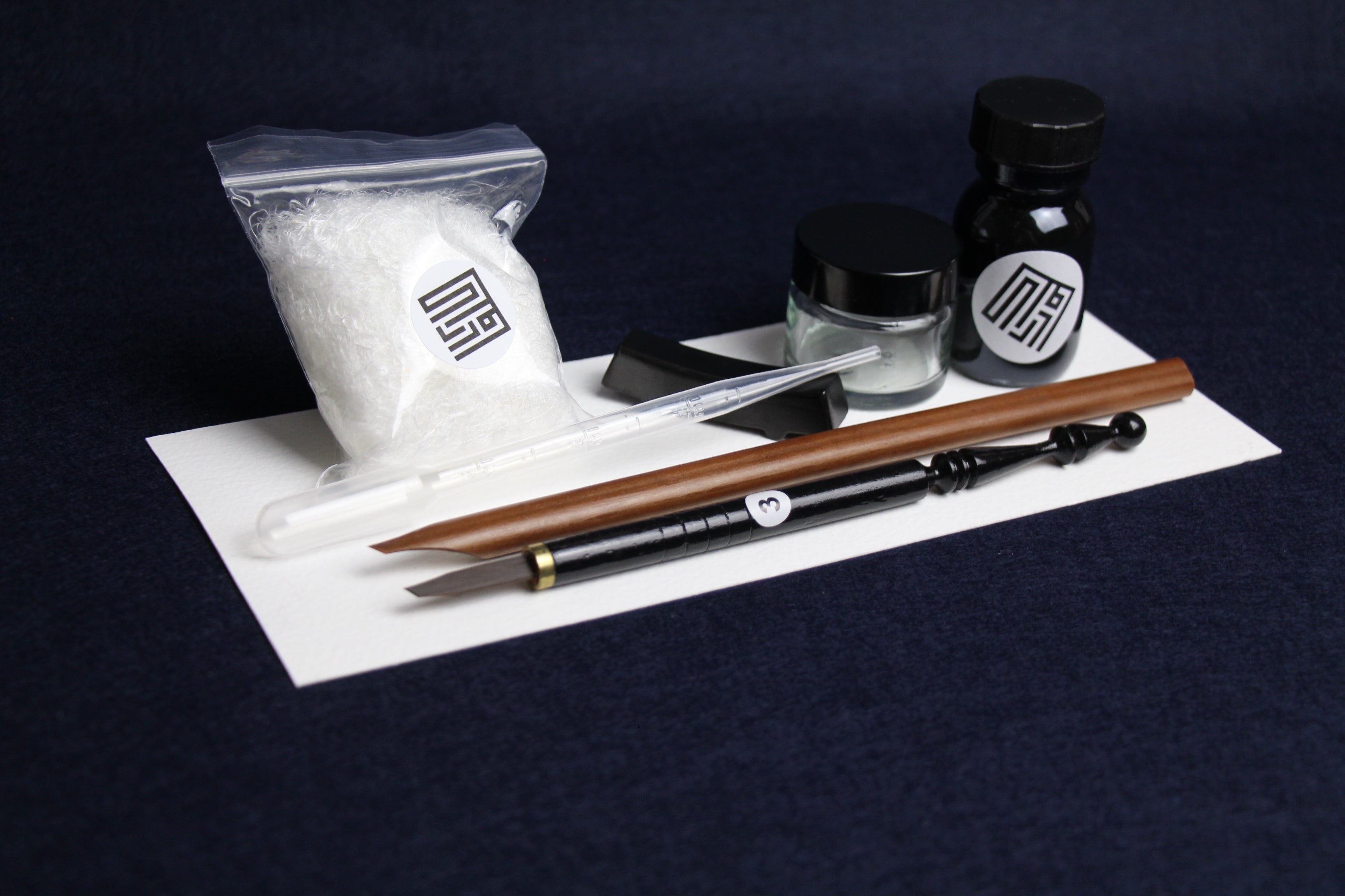 Small set for Arabic calligraphy - two dip pens with left oblique nib - Javi, handam, small glass inkwell with silk killa, black Indian ink in glass bottle, black metal pen rest and plastic transfer pipette