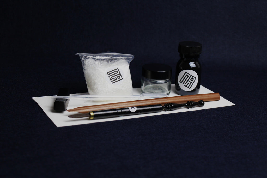 Small set for Arabic calligraphy - two dip pens with left oblique nib - Javi, handam, small glass inkwell with silk killa, black Indian ink in glass bottle, black metal pen rest and plastic transfer pipette